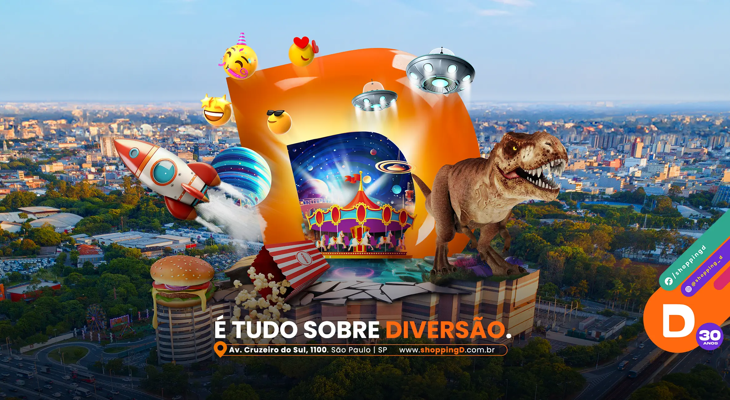 Banner promocional do Shopping D com elementos lúdicos como emojis, foguete, dinossauro, pipoca e carrossel, em um ambiente de diversão. O texto diz: 'É tudo sobre diversão.' A localização e informações do shopping aparecem abaixo: Av. Cruzeiro do Sul, 1100, São Paulo, SP. www.shoppingD.com.br - Shopping D